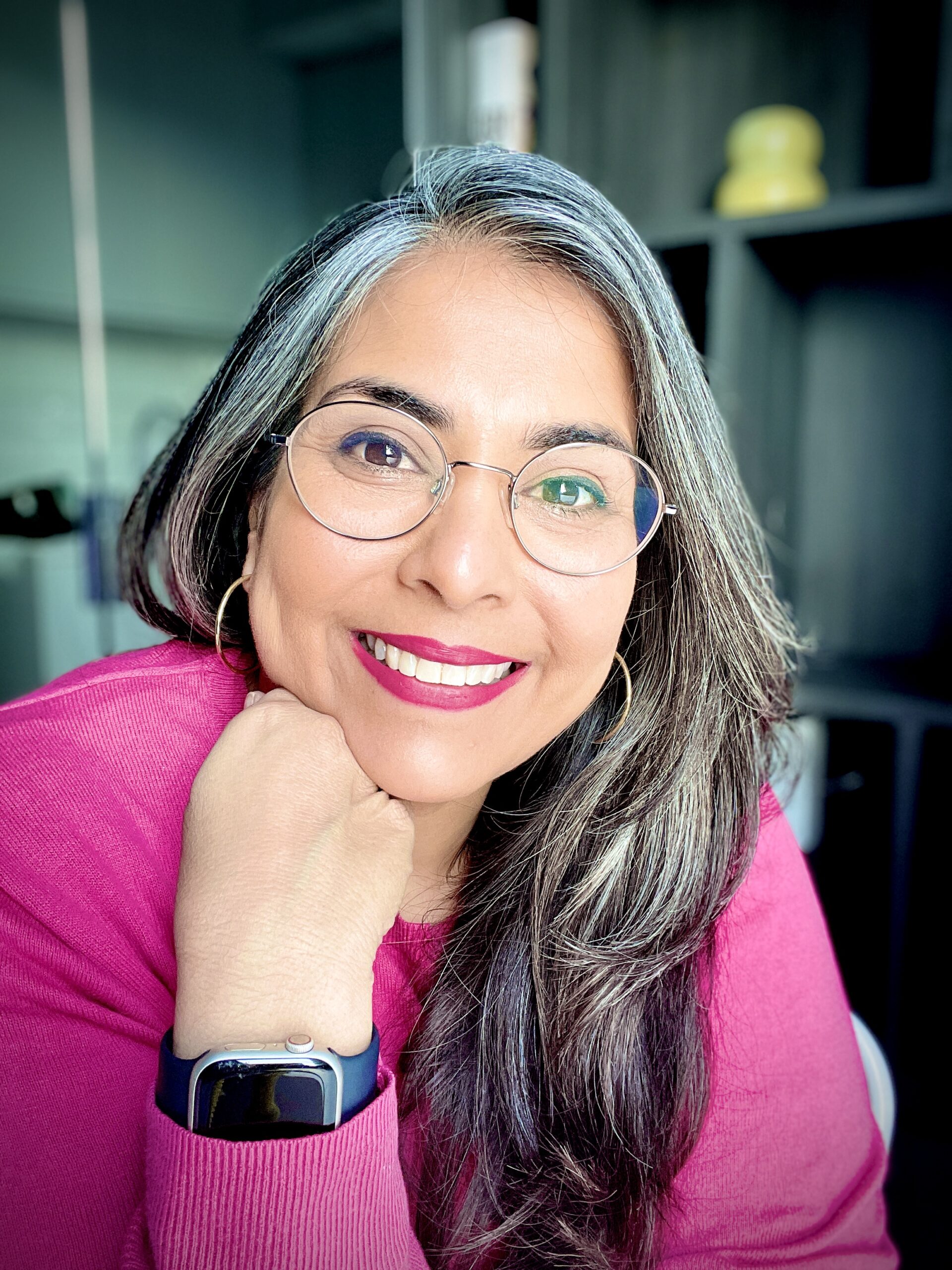 Photo of a smiling woman, Kirti, dressed in pink and wearing glasses